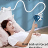 A woman is using a multifunctional mobile phone holder with a flexible gooseneck to hold her phone while lying in bed.