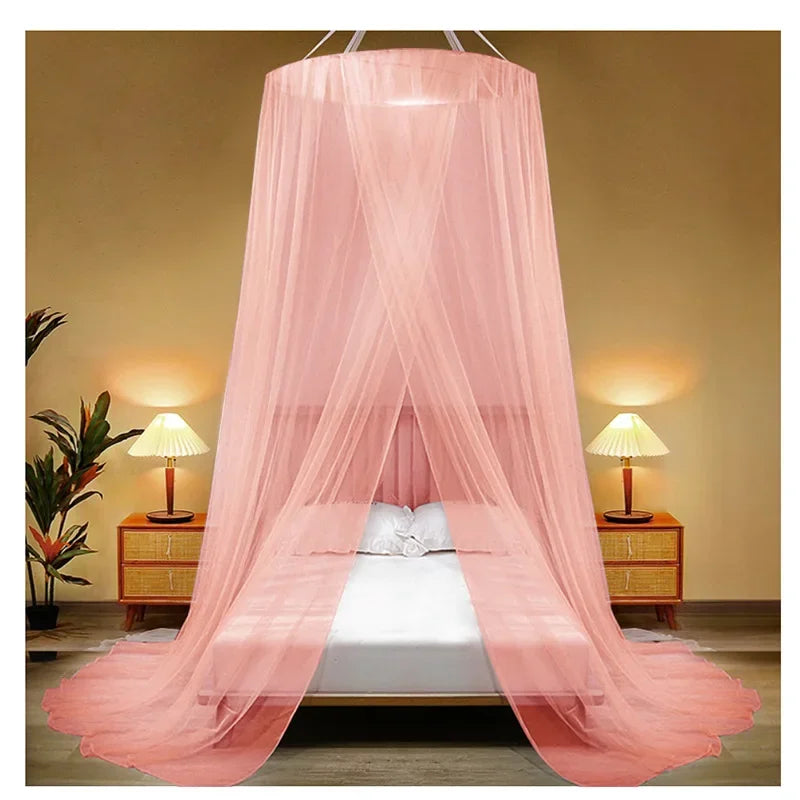 Pink sheer canopy mosquito net draped over a double bed in a bedroom setting