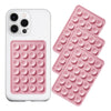 A white phone case and a pink silicone suction pad with multiple circular bumps for mounting devices.