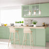 A kitchen featuring light green cabinetry, a wooden countertop, and pendant lights above a dining area.