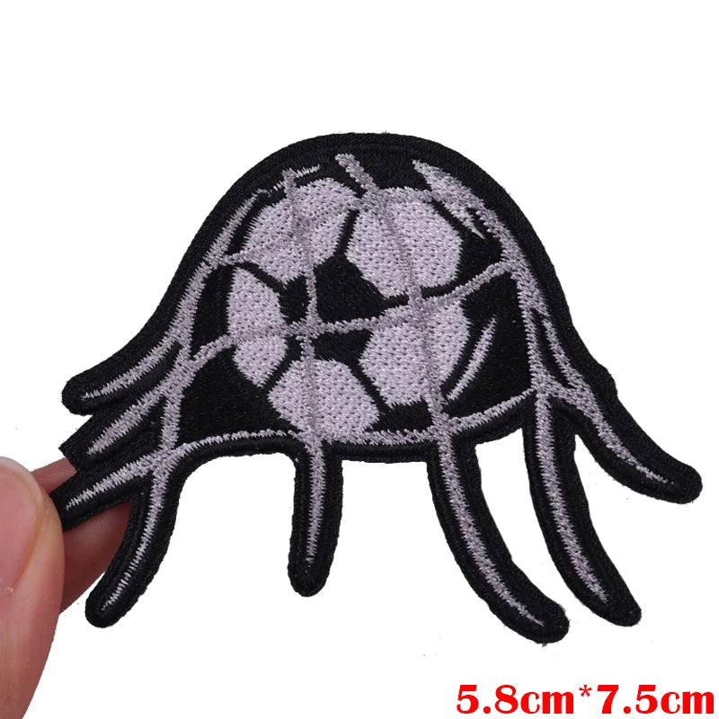 Black and white embroidered patch shaped like a hand with a soccer ball design