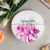 Fleurs d'orchidée roses présentées sur un moule silicone blanc circulaire avec une ligne de mesure.
