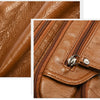 Close-up of a brown leather tote bag showing stitching and texture.