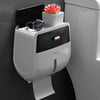 Porta papel higiénico impermeable montado en la pared, blanco, que sostiene un smartphone negro y un reloj.
