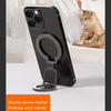 Black magnetic phone holder with a ring and kickstand resting on a white table.