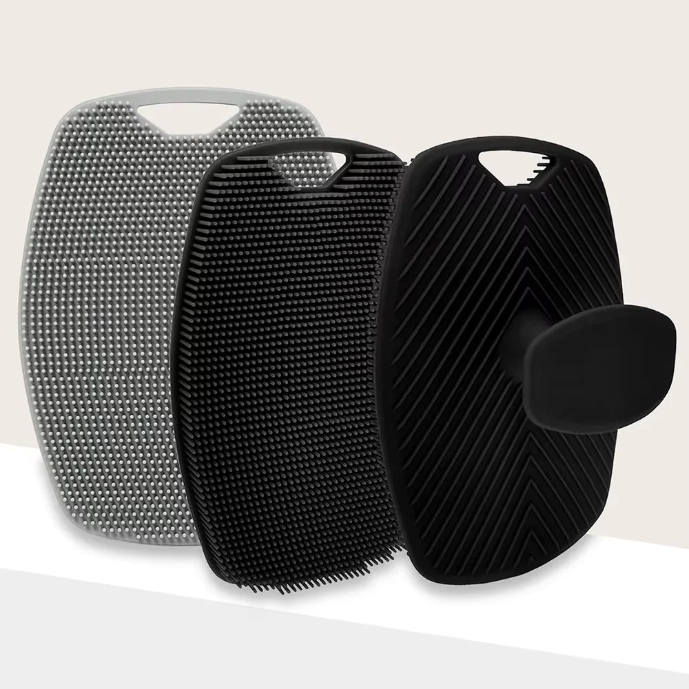 A set of two silicone body scrubbers or massage brushes, one silver and one black, shown against a light background.