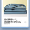 A stack of light blue comforters with gold embroidery, featuring the Dreamcity brand.