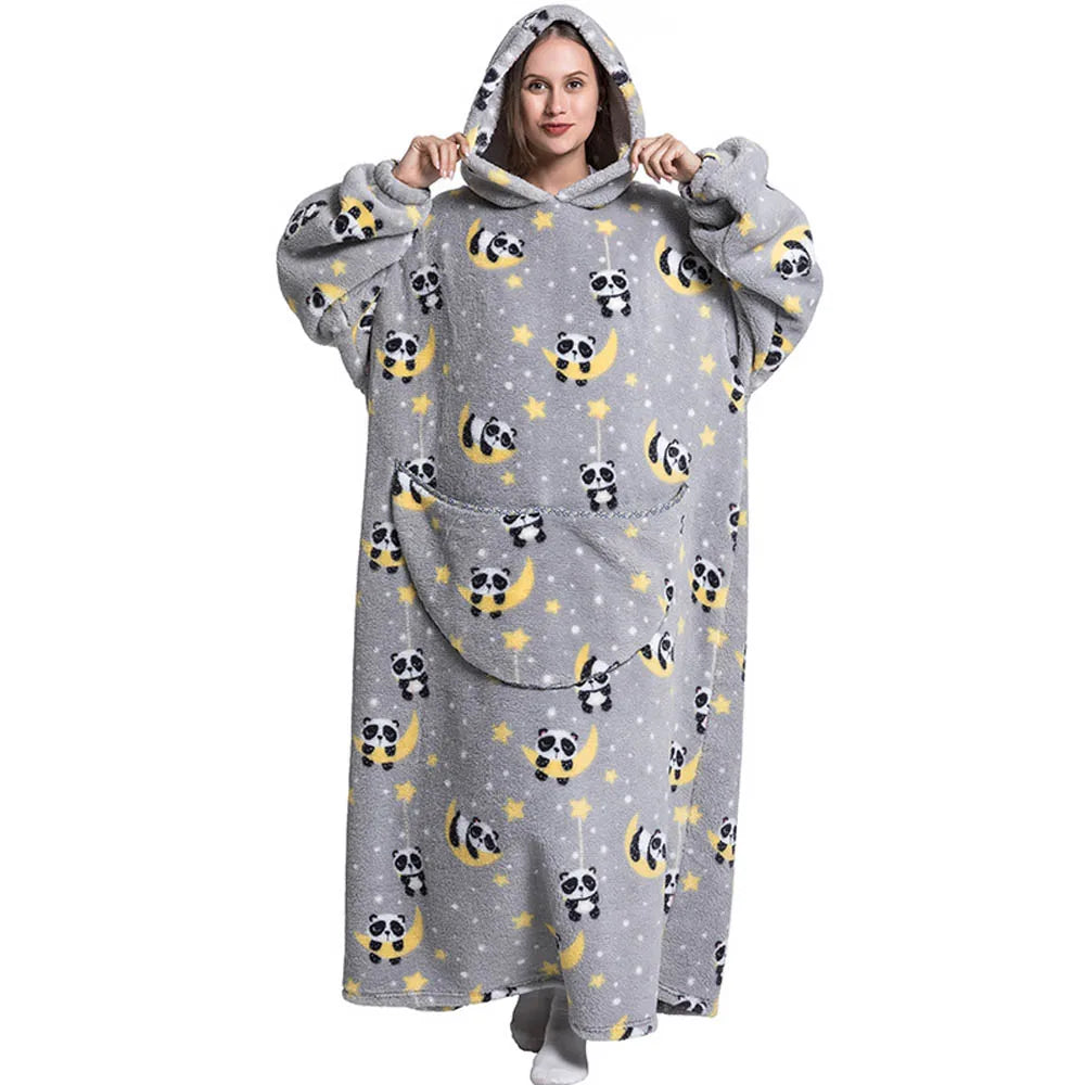 A woman wearing a gray hoodie blanket featuring a pattern of cute panda faces on a light background.