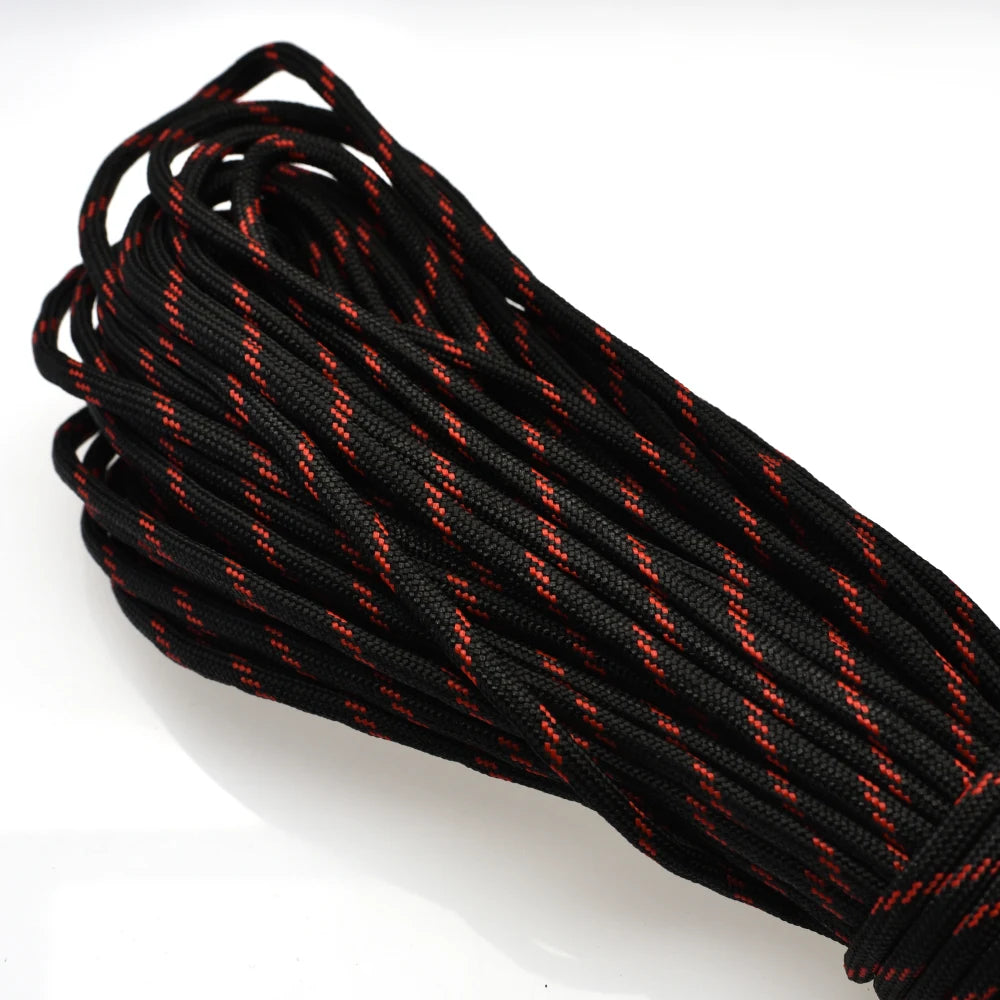 A coil of black paracord rope with orange accents, showing the twisted strands and texture.
