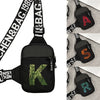 Black canvas chest bag with an embroidered green letter K and black strap