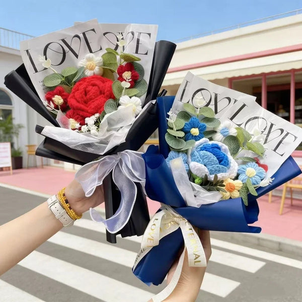 A hand holds a bouquet of handmade crochet artificial flowers in black and blue paper wrapping.