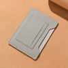 A light gray ultra-thin passport holder with card slots lying on a beige surface.