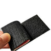 A hand holds an embroidered hook and loop patch with reflective accents, showing the texture and detail of the fabric.