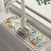 A modern kitchen faucet with a floral mat featuring white and orange leaves is installed on the sink.