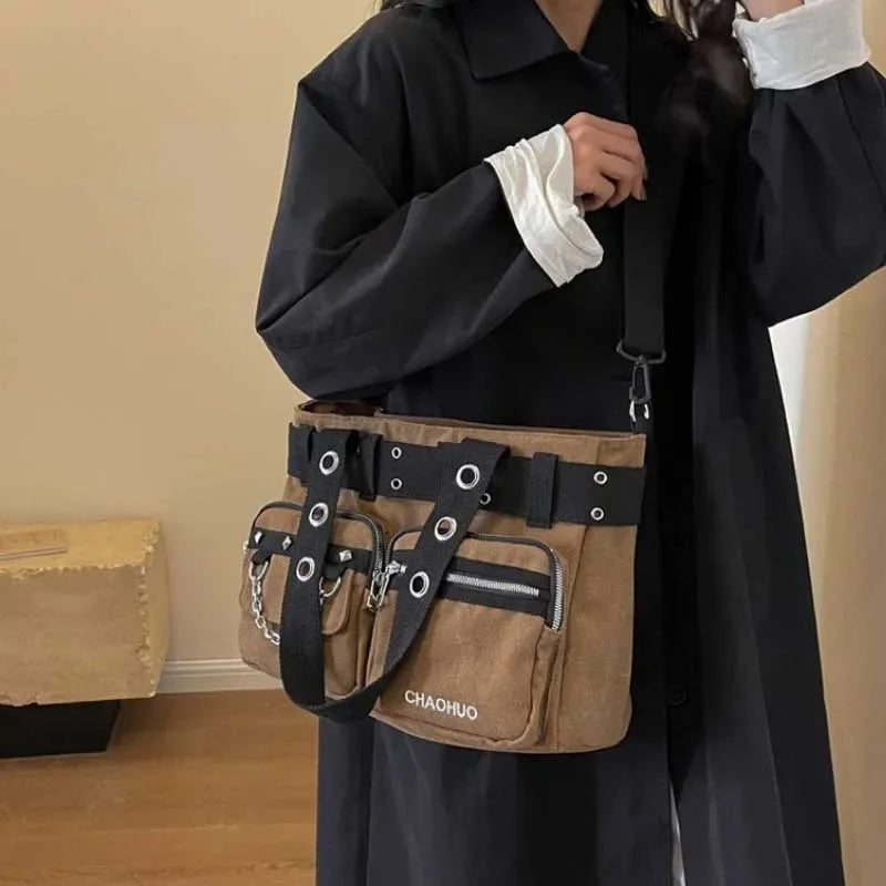 A black coat sleeve shows a tan nylon shoulder bag with black leather straps and silver chain accents.