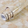 Roll of marble contact paper in beige and cream tones laid across a tiled surface.