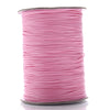 A spool of pink waxed cotton cord used for jewelry making