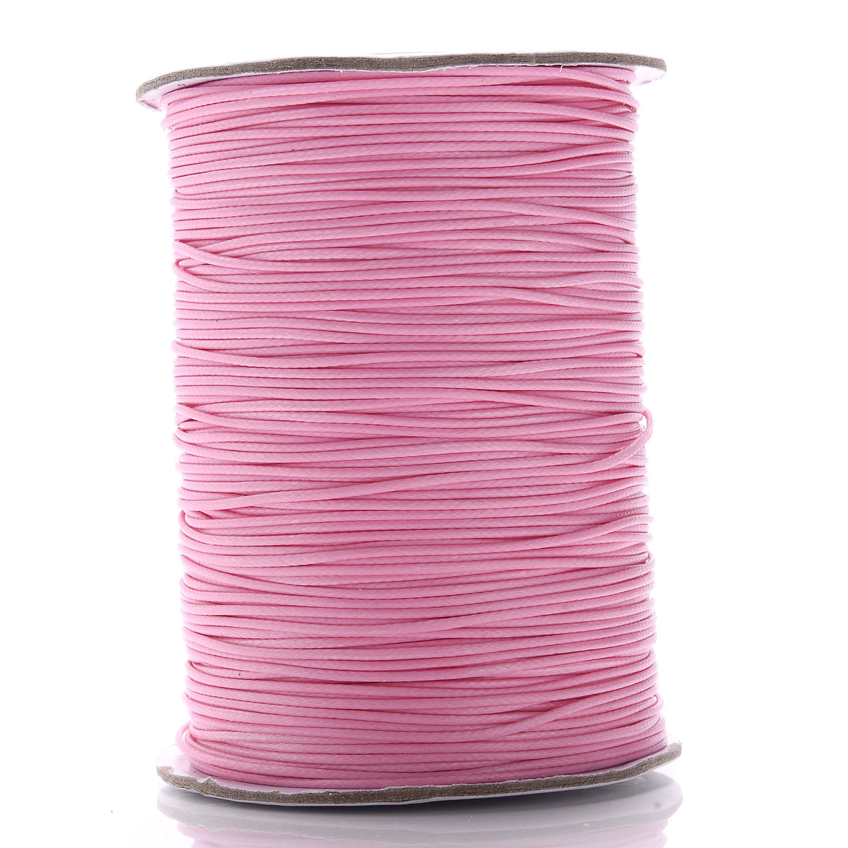 A spool of pink waxed cotton cord used for jewelry making