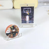 A clear acrylic display stand holds a photo of a basketball player in a game setting.