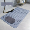 A dark grey non-slip suction cup bath mat with massage nodes placed on a light surface.