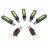 A set of realistic cockroach prank gum toys in green packaging and cardboard holders.