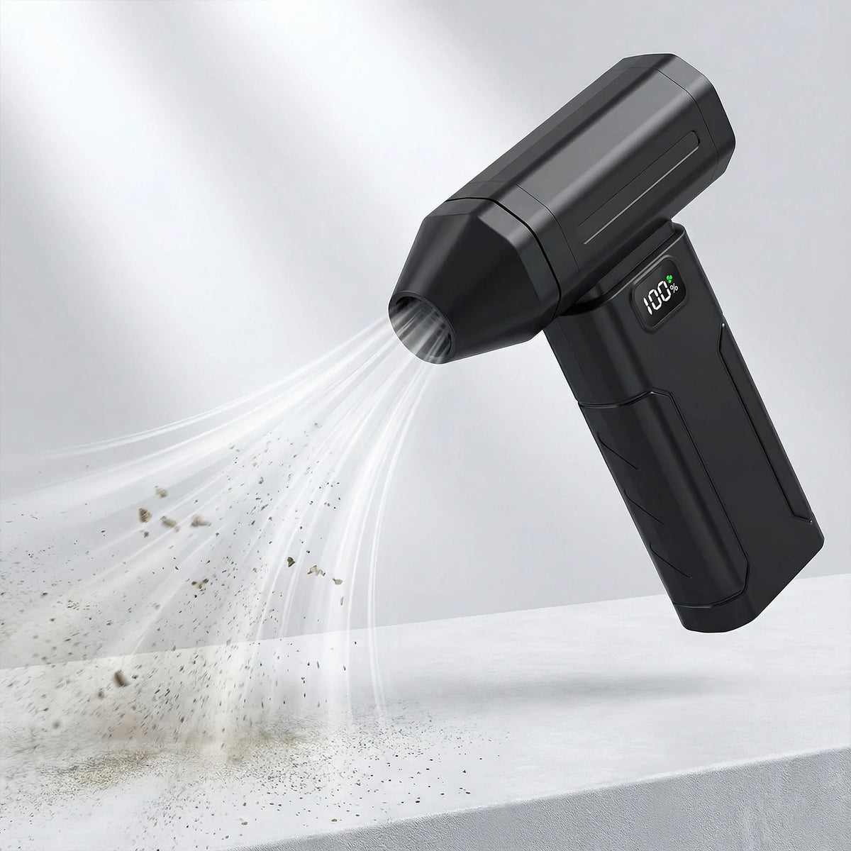 A black high-speed cordless air duster is shown emitting a fine mist of air onto a white surface.