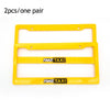 A pair of yellow racing style license plate frames with fake taxi text.