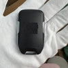 A black replacement remote key is held in a person's hand against a white background.