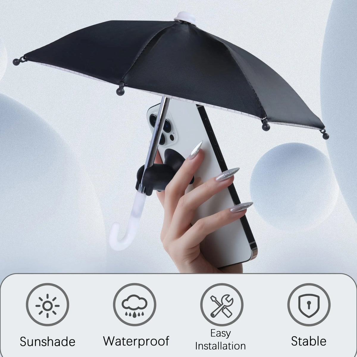 A hand holds a black umbrella stand with a suction cup that supports a smartphone, demonstrating its stable installation.