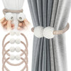 Pearl magnetic curtain tiebacks with a braided cord and pearl accents used to hold gray fabric curtains.