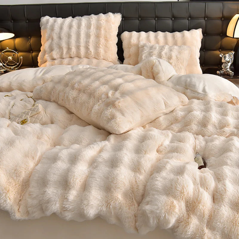 A fluffy cream colored plush bedding set featuring pillows and a duvet on a bed.