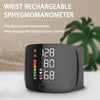 A black wrist rechargeable sphygmomanometer device displaying blood pressure readings and a green plant in the background.