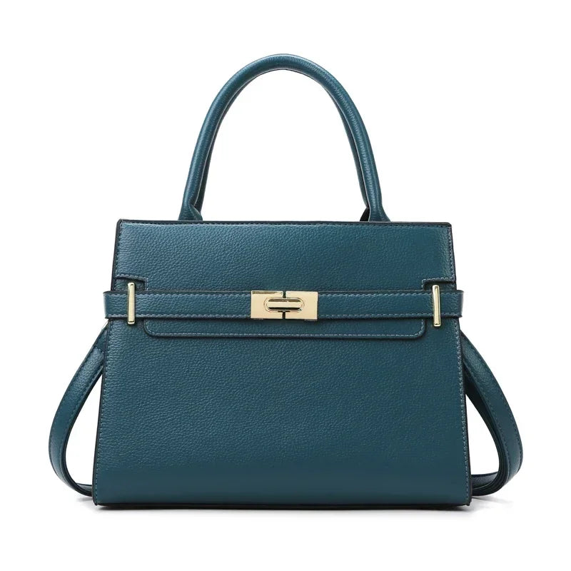 A dark teal leather handbag with a top handle and matching coin purse.