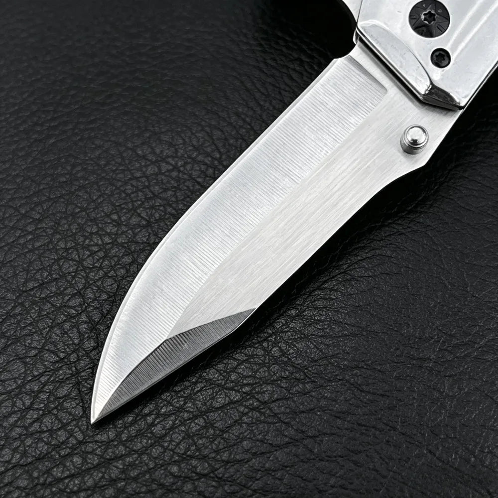 A folding pocket knife with a stainless steel blade and a visible silver blade edge resting on black leather.