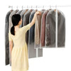 A woman is hanging transparent zippered garment storage bags on a rack.
