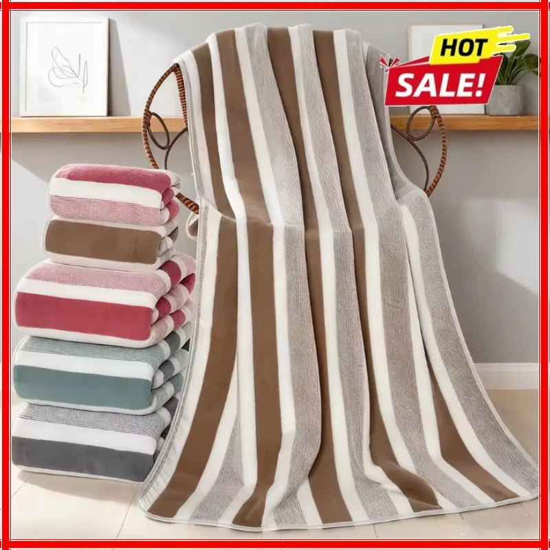 A set of striped bath towels in shades of brown, beige, pink, and gray hanging on a rack.