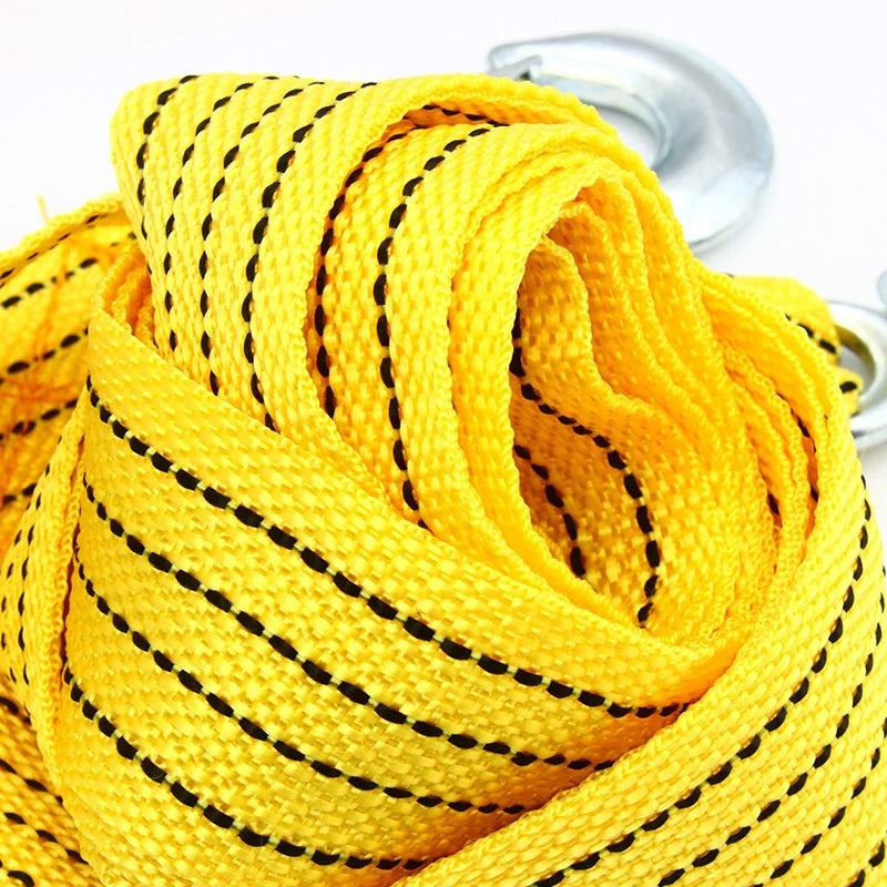 Yellow heavy-duty vehicle recovery towing strap coiled and visible with a metal hook.