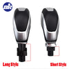 A pair of gear shift knobs, one long style and one short style, for a Ford vehicle.
