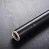 Roll of self-adhesive wood grain waterproof wallpaper on a dark surface