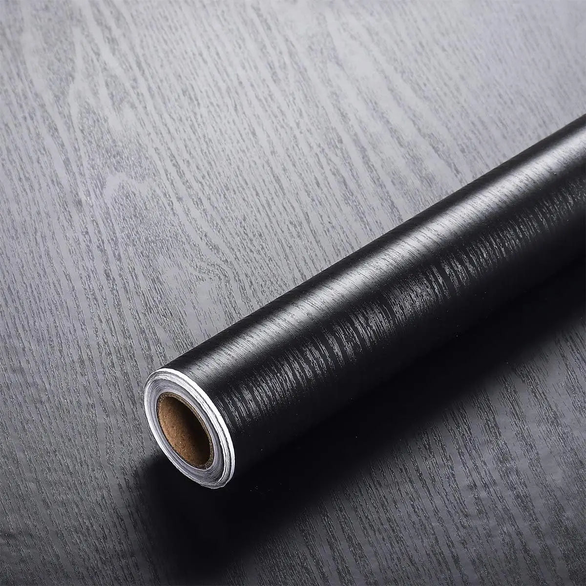 Roll of self-adhesive wood grain waterproof wallpaper on a dark surface