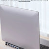 A silver laptop is shown with a 12-in-1 USB-C docking station connected to it on a wooden surface.