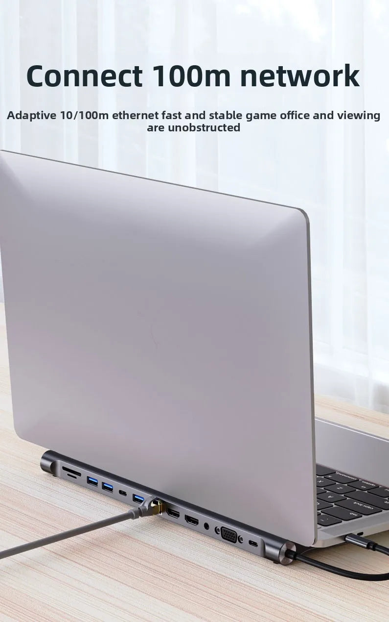A silver laptop is shown with a 12-in-1 USB-C docking station connected to it on a wooden surface.