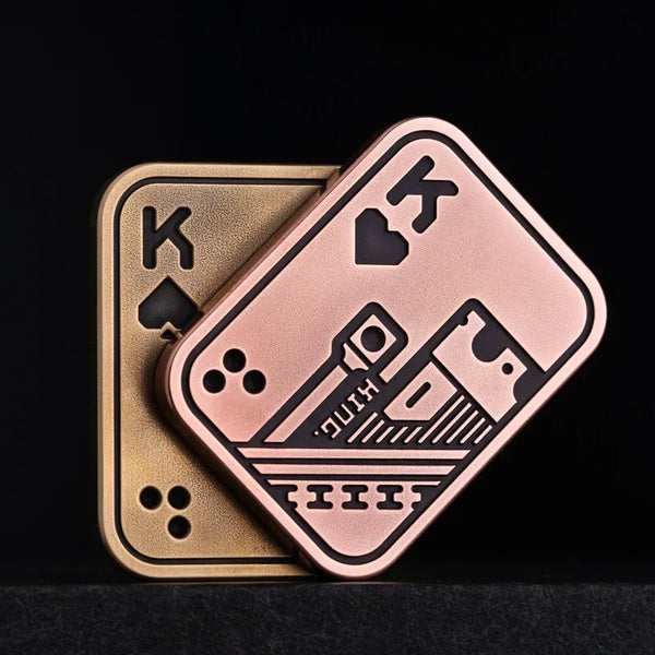 A pink metal poker card with a king and heart design rests on a gold-colored card.