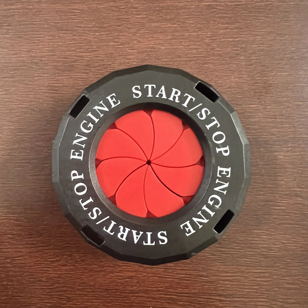 A black circular button cover with red accents and text reading START/STOP ENGINE.