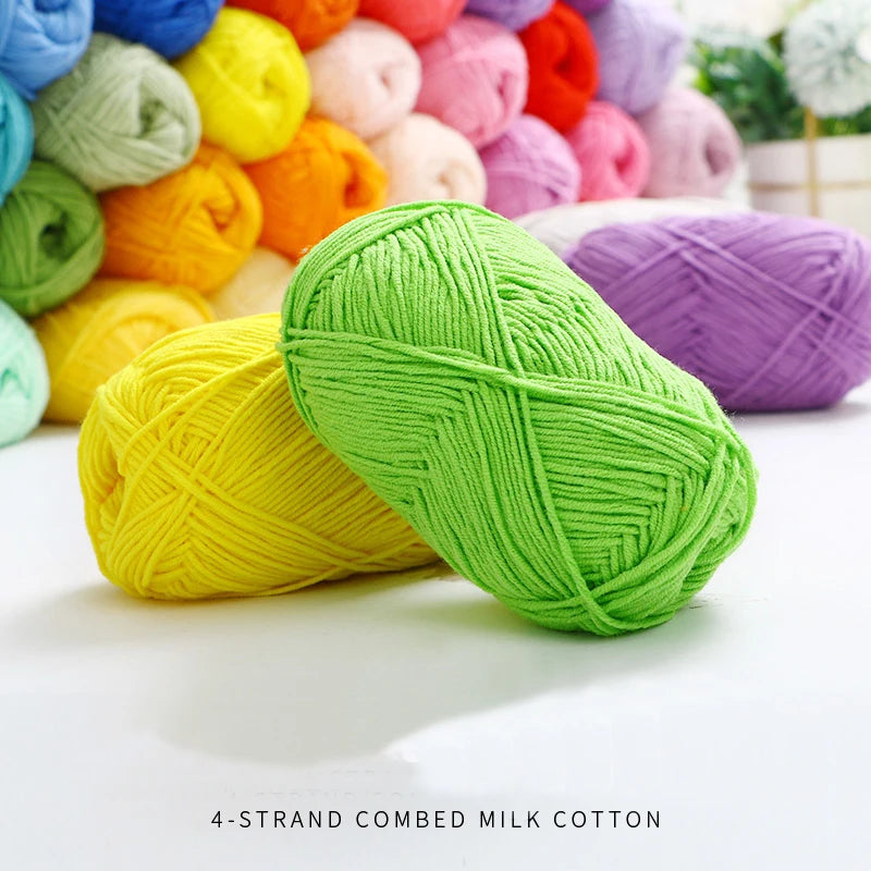 A pile of bright lime green 4-strand combed milk cotton yarn next to various colored yarns.