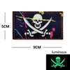 A dark blue embroidered patch featuring a white skull and crossed swords with colorful accents.