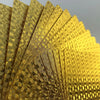 A close-up of a fan of 24K gold waterproof playing cards showing intricate geometric patterns.