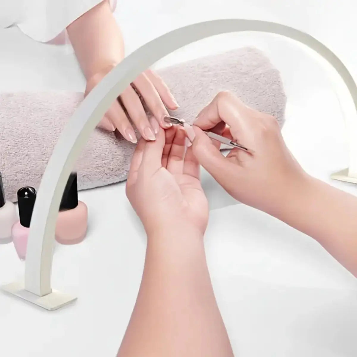 Hands are using a half-moon LED arc desk lamp to perform nail art or lash extensions.