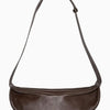 Braune Leder-Crossbody-Tasche mit langer Trageleiste vor weißem Hintergrund
