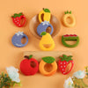 A collection of silicone fruit-shaped baby rattles and teethers in various colors like red, yellow, green, and purple.